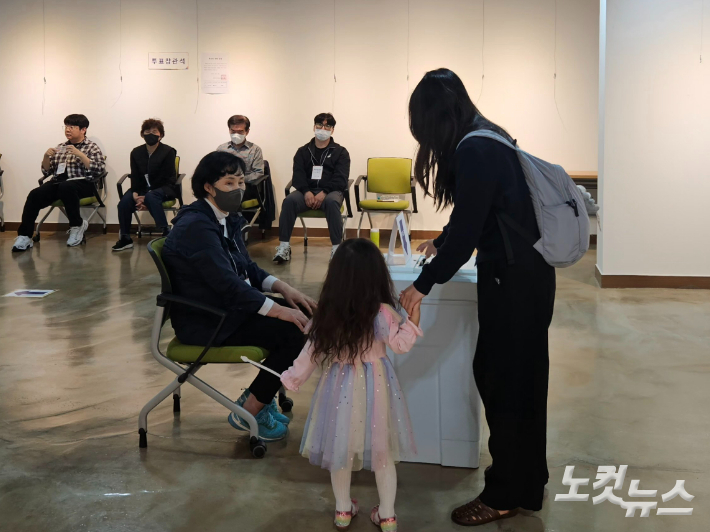 제21대 대통령선거 투표일인 3일 부산 수영구 생활문화센터에 마련된 광안2동 제2투표소에서 한 유권자가 자녀와 함께 소중한 한 표를 행사하고 있다. 김혜민 기자 