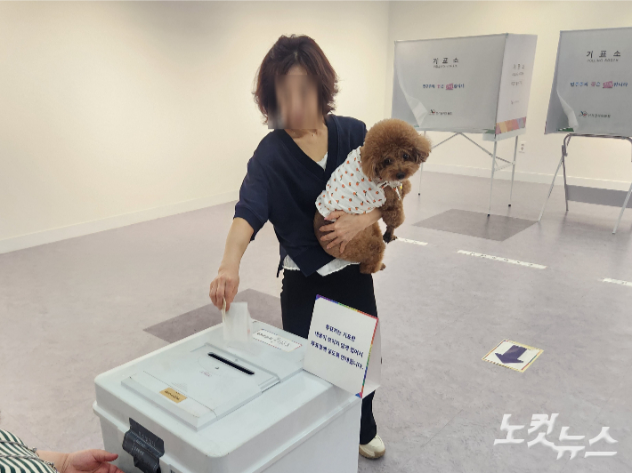 제21대 대통령선거 본투표가 치러지는 3일 오후, 부산진구청에 마련된 투표소에서 한 유권자가 반려견과 함께 투표하고 있다. 정혜린 기자