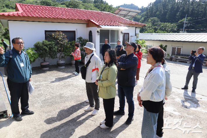 평리교회를 방문한 성지순례팀이 채동우 집사(좌측)의 설명을 듣고 있다. 유상원 아나운서