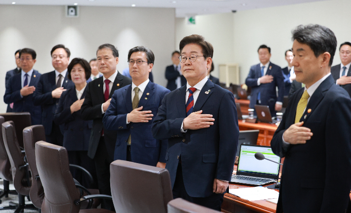 이재명 대통령이 5일 서울 용산 대통령실 청사에서 주재한 첫 국무회의에서 국기에 경례하고 있다. 연합뉴스