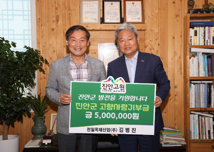 전춘성 진안군수가 500만원을 기탁한 전일목재산업 김병진 대표이사(오른쪽)와 기념 촬영을 하고 있다. 진안군 제공