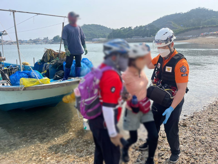 지난 6월 1일 오후 3시 33분께 쥐똥섬에서 관광을 하던 60대 부부가 고립됐다가 구조되고 있다. 군산해경 제공