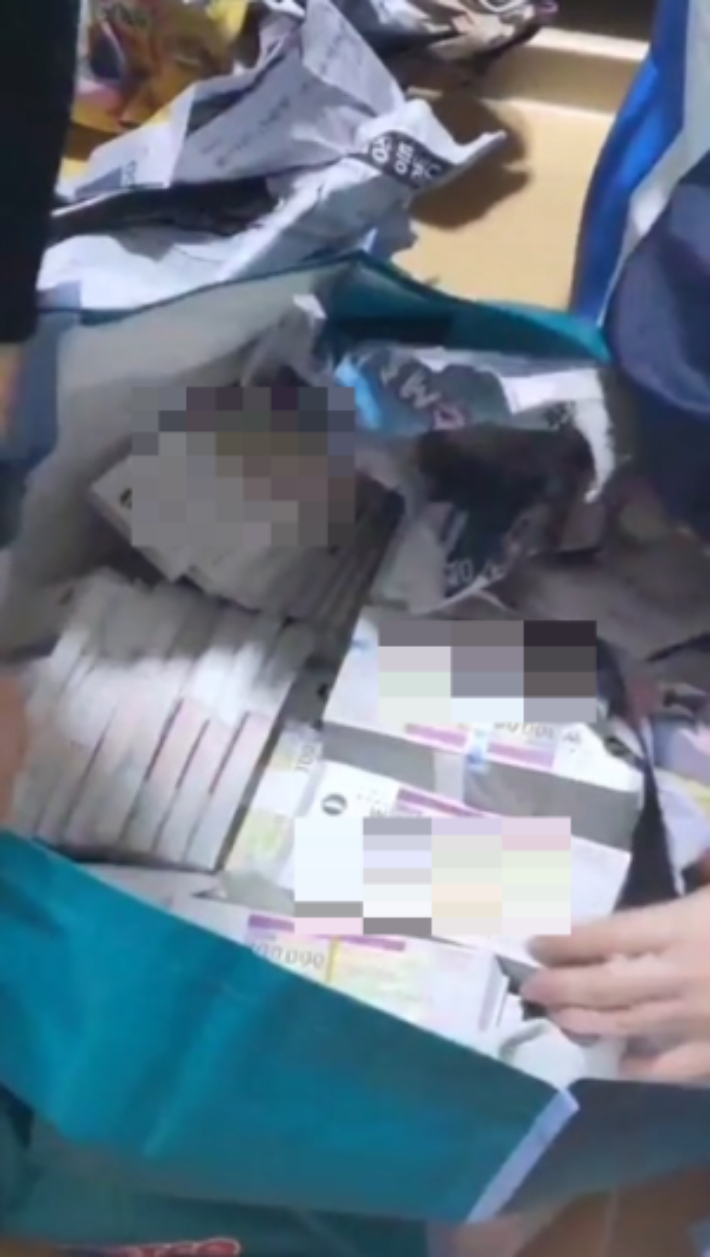 세무당국이 고액상습체납자 B씨의 거주지에서 쓰레기 더미 위에 덮인 신문지를 걷어내자 10만 원권 수표다발이 발견됐다. 국세청 제공 