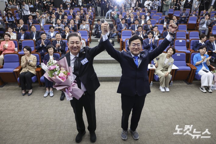 더불어민주당 김병기 신임 원내대표가 13일 서울 여의도 국회에서 열린 제22대 국회 더불어민주당 제2기 원내대표 선출 의원총회에서 꽃다발을 들고 기념촬영을 하고 있다. 2025.6.13