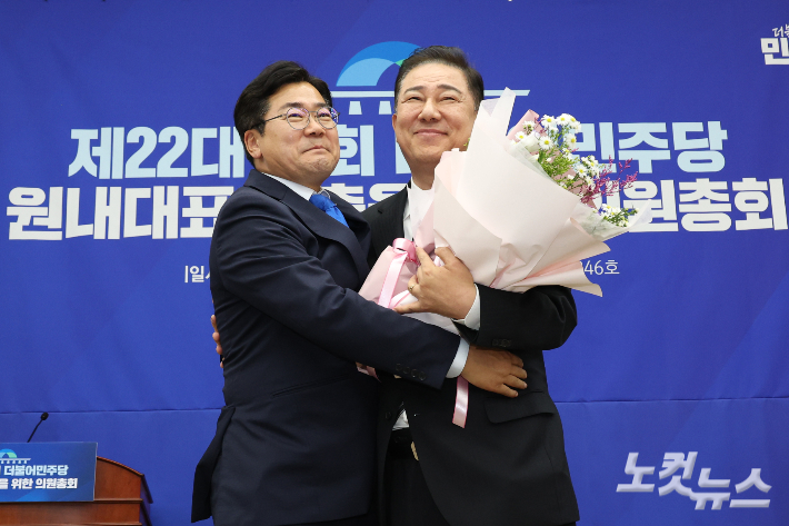 더불어민주당 김병기 신임 원내대표가 13일 오후 서울 여의도 국회에서 열린 제2기 원내대표 선출 의원총회에서 원내대표로 선출된 뒤 박찬대 전 원내대표로부터 꽃다발을 받고 포옹하고 있다. 윤창원 기자