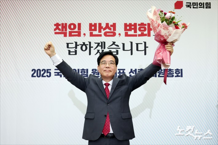 송언석 국민의힘 신임 원내대표가 16일 오후 서울 여의도 국회에서 열린 2025 국민의힘 원내대표 선출 의원총회에서 꽃다발을 든 채 손을 들어올리고 있다.