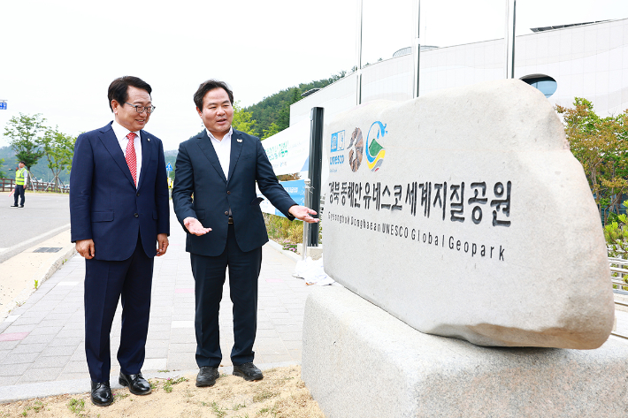 손병복 울진군수와 김학홍 경북도 행정부지사가 경북동해안 유네스코 세계지질공원 기념석을 살펴보고 있다. 울진군 제공