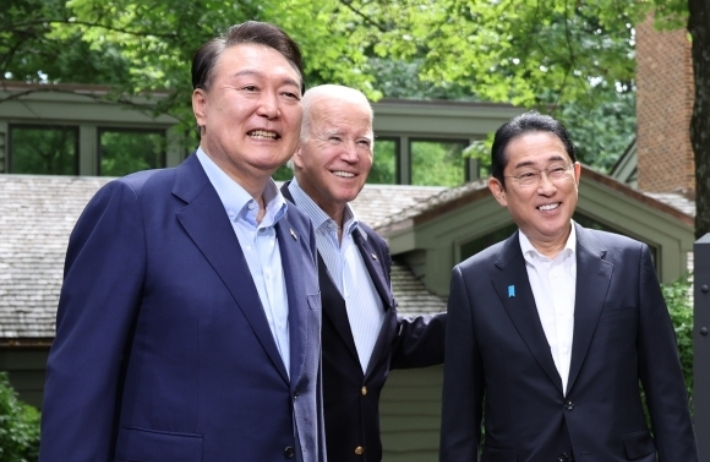 2023년 8월 당시 윤석열 전 대통령(왼쪽부터), 조 바이든 전 미국 대통령, 기시다 후미오 전 일본 총리가 미국 워싱턴DC 인근 미국 대통령 별장인 캠프 데이비드에서 열린 정상회의를 앞두고 로렐 로지 앞에서 기념 사진을 찍고 있다. 연합뉴스