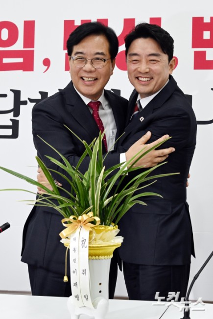 강훈식 대통령 비서실장이 17일 서울 여의도 국회에서 국민의힘을 찾아 송언석 원내대표에게 이재명 대통령의 축하 난을 전달하고 포옹을 하고 있다.