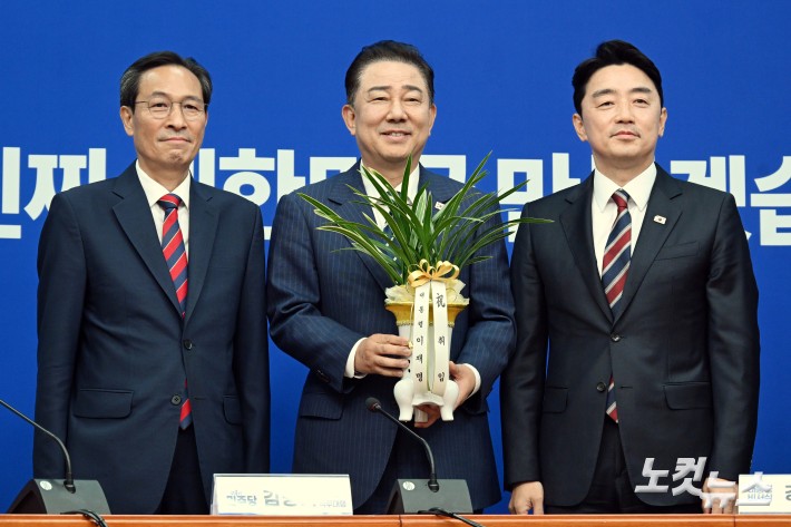 강훈식 대통령 비서실장이 17일 서울 여의도 국회에서 더불어민주당을 찾아 김병기 당대표 직무대행 겸 원내대표(가운데)에게 이재명 대통령의 축하 난을 전달하고 있다. (왼쪽 우상호 정무수석)