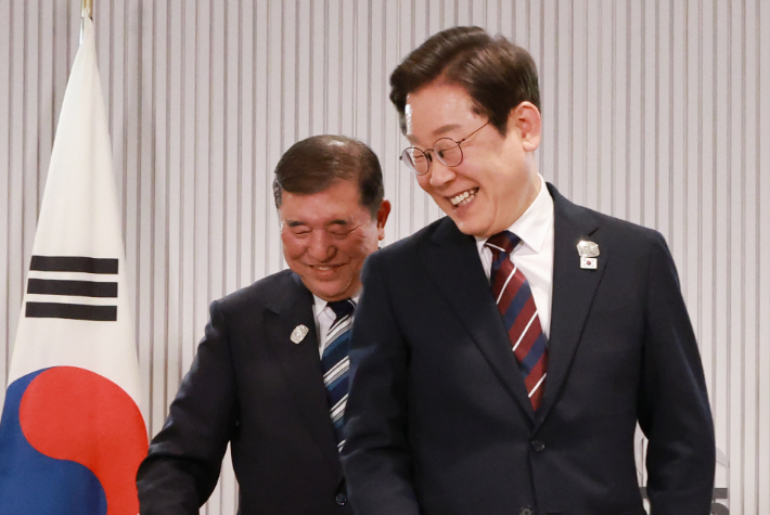 이재명 대통령이 17일(현지시간) 캐나다 앨버타주 캐내내스키스 주요 7개국(G7) 정상회의장에서 열린 한일 정상회담에서 이시바 시게루 일본 총리와 자리를 바꾸며 밝게 웃고 있다. 연합뉴스