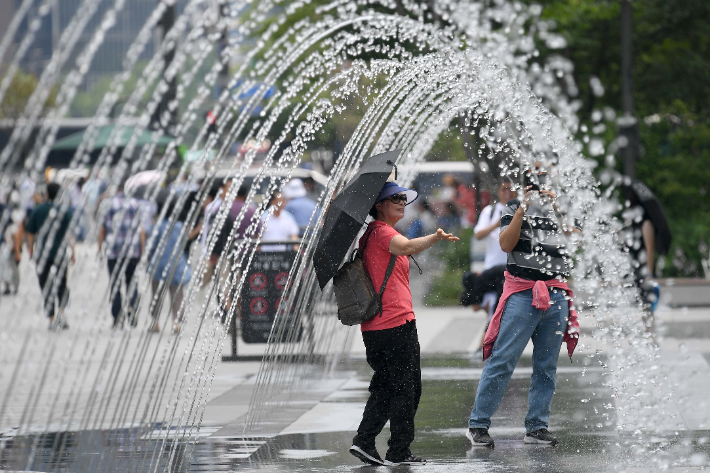 서울 광화문광장에서 관광객들이 더위를 식히고 있다. 박종민 기자