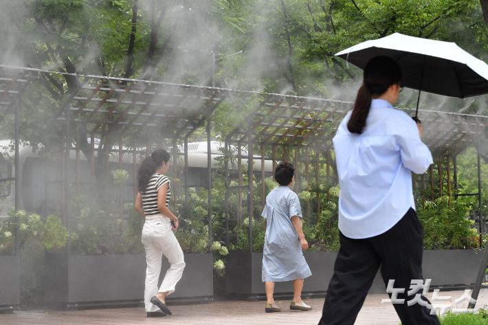 쿨링포그 아래로 지나가고 있는 시민들. 류영주 기자