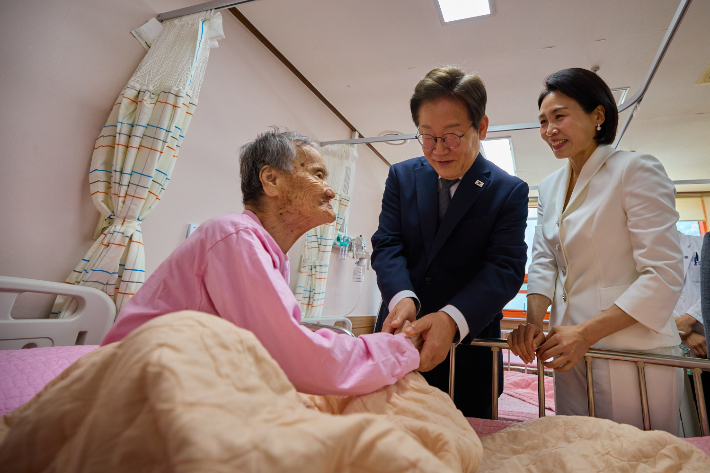 이재명 대통령과 김혜경 여사가 25일 전남 고흥군 국립소록도병원에서 한 환자를 위로하고 있다. 대통령실 제공