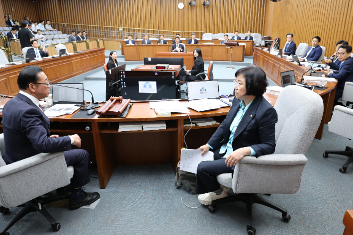 25일 서울 국회에서 열린 김민석 국무총리 후보자 인사청문회에서 국민의힘 소속 이종배 위원장과 여당 간사인 더불어민주당 김현 의원이 청문회 속개 시간 등과 관련해 대화하고 있다. 연합뉴스