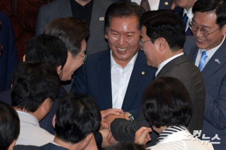 이재명 대통령이 26일 서울 여의도 국회에서 열린 본회의에서 2025년도 제2회 추가경정예산안에 대한 정부의 시정연설을 마치고 회의장을 나서며 더불어민주당 당대표에 출마한 정청래· 박찬대 의원과 손을 잡고 있다.