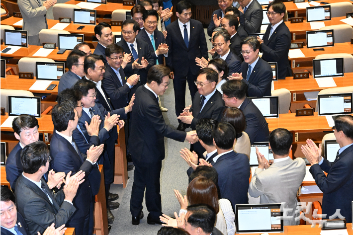 이재명 대통령이 26일 오전 서울 여의도 국회에서 2025년도 제2회 추가경정예산안에 대한 정부의 시정연설을 하기 위해 본회의장에 입장하며 더불어민주당 의원들과 악수하고 있다. 윤창원 기자