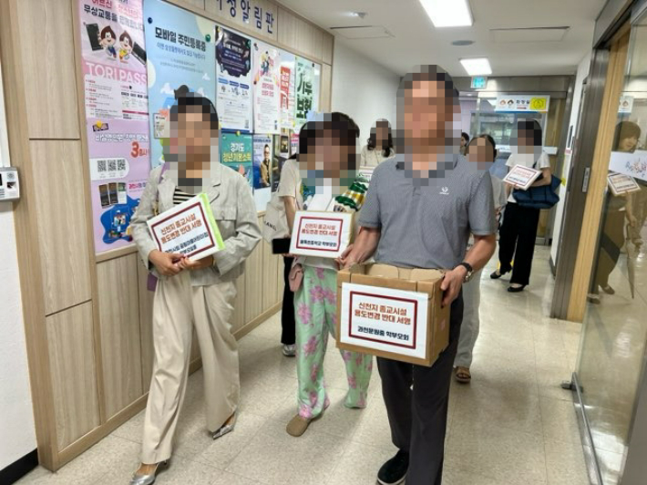27일 과천시의 한 학부모 단체가 신천지 종교시설 용도변경 반대 서명부를 들고 과천시청 민원실을 방문했다. 독자 제공