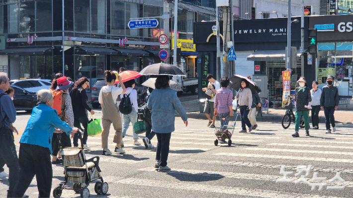 대구 서구의 한 거리에서 시민들이 양산으로 햇빛을 가리며 걷고 있다. 정진원 기자