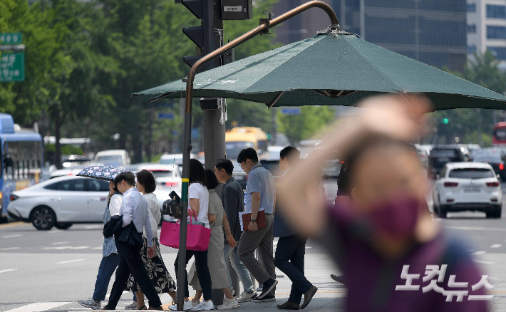 차양막 아래 시민들이 발걸음을 옮기고 있다. 박종민 기자