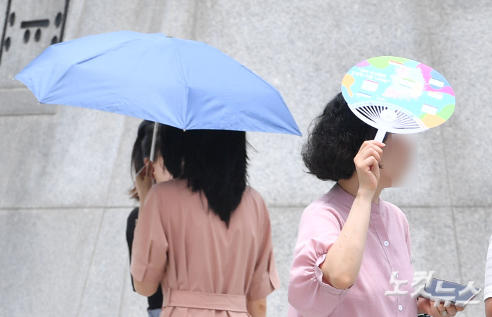 서울에 올해 첫 폭염주의보가 내려진 30일 오후 서울 종로구 광화문 광장에서 시민들이 양산과 부채를 들고 있다. 류영주 기자