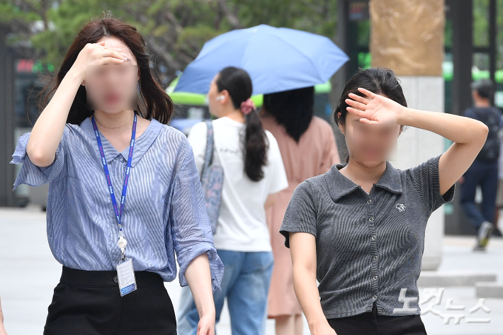 시민들이 손으로 햇빛을 가리며 걷고 있다. 류영주 기자