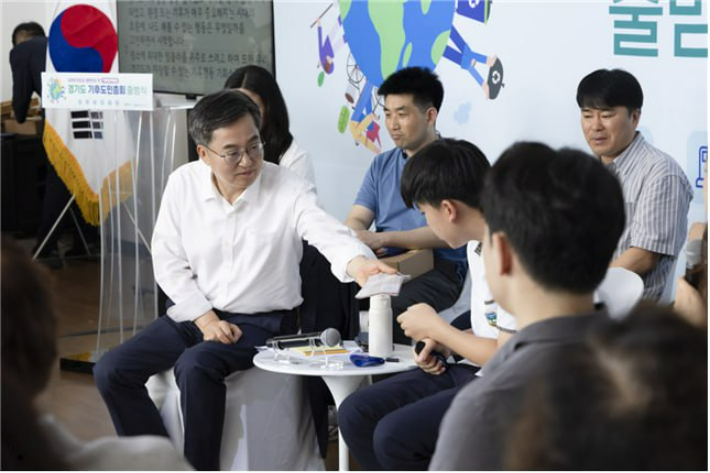 김동연 도지사가 지난달 30일 시흥에코센터에서 진행된 '경기도 기후도민총회 출범식'에서 도민 참가자에게 손수건을 건네고 있다. 경기도 제공