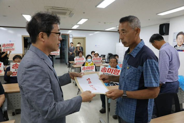 농민 대표(우측)가 송미령 장관 유임 항의 서한을 민주당 전남도당 측에 전달하고 있다. 전농 제공 