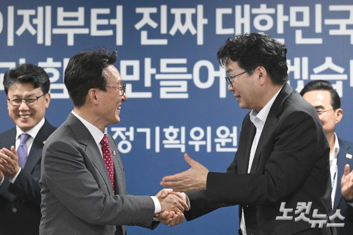 김민석 국무총리와 이한주 국정기획위원회 위원장이 7일 오후 서울 종로구 국정기획위원회에서 열린 제4차 전체회의에서 기념촬영을 마친 뒤 악수를 하고 있다. 정부청사사진기자단