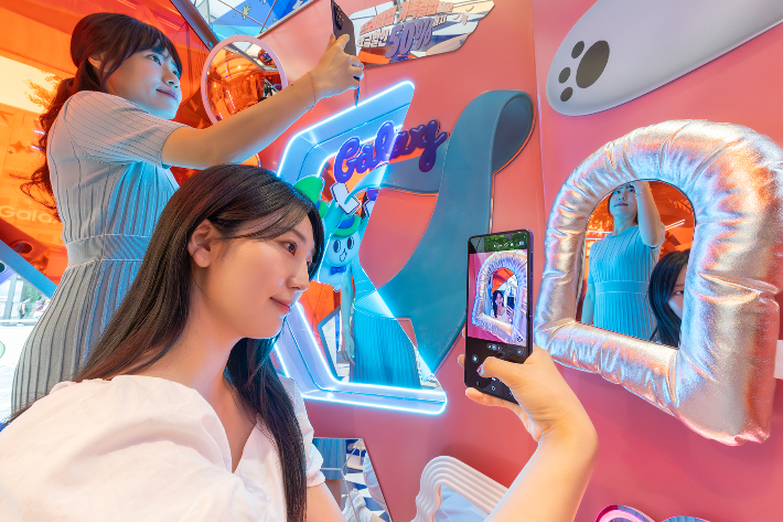 모델들이 KT 홍대 애드샵 플러스에 마련된 '갤럭시 Z 폴더블7 AI 체험존'에서 AI 기반 콘텐츠를 체험하고 있다. KT 제공