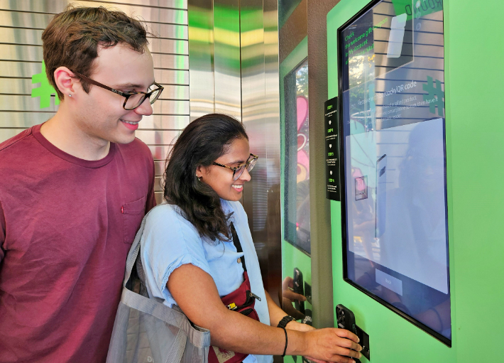 미국인 탄비(Tanvi, 오른쪽)씨와 러셀(Russell, 왼쪽)씨가 올리브영 명동 타운에 마련된 벤딩머신으로 글로벌몰에 가입하는 모습. CJ올리브영 제공