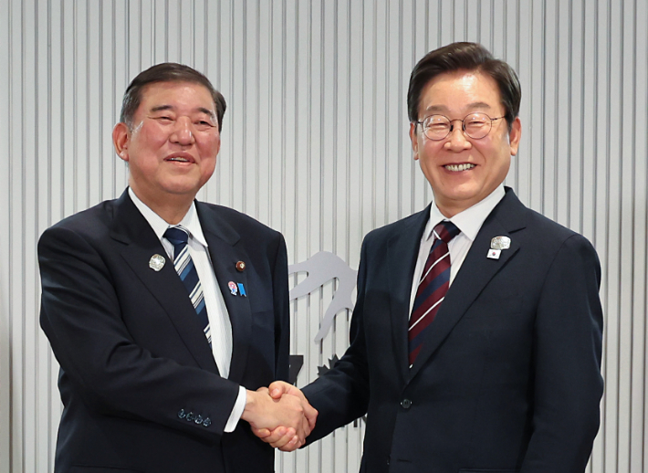 이시바 시게루 일본 총리와 악수하며 기념촬영을 하는 이재명 대통령. 연합뉴스