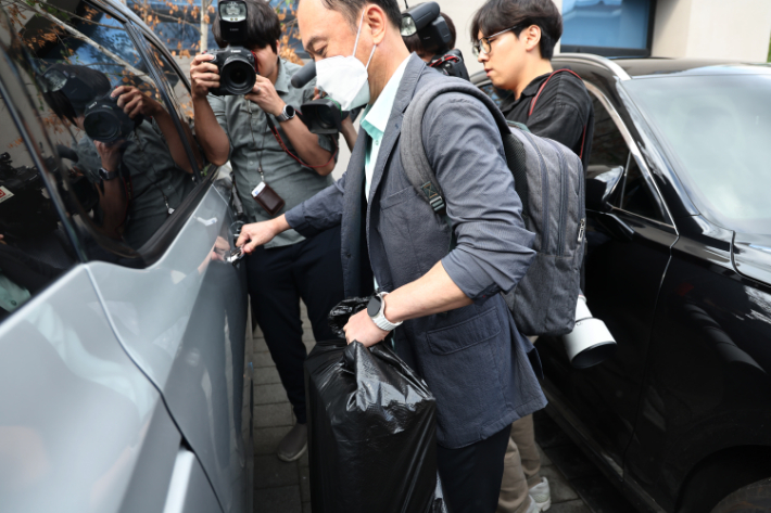  김건희 여사 관련 의혹들을 수사하는 민중기 특별검사팀이 15일 서울 역삼동 건진법사 전성배 씨의 법당에 대한 압수수색을 마친 후 관련 물품을 들고 차로 향하고 있다. 연합뉴스