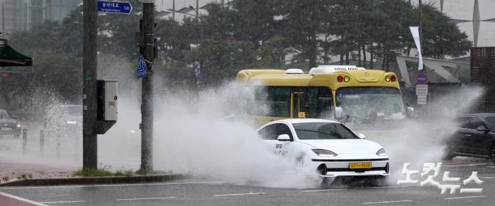 기습 폭우가 쏟아진 17일 서울 송파구 잠실역 인근에서 차량들이 물보라를 일으키며 주행하고 있다.