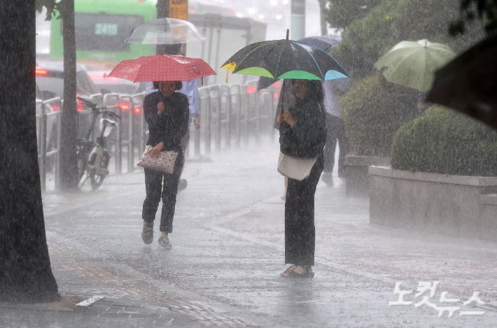 기습 폭우가 쏟아진 17일 서울 송파구 잠실역 인근에서 우산을 쓴 시민들이 발걸음을 옮기고 있다. 박종민 기자