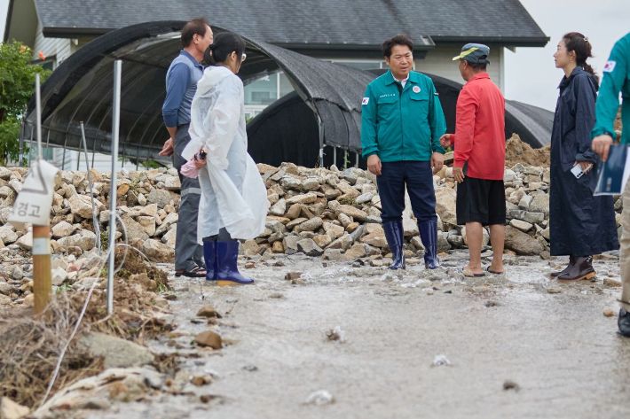 오세현 아산시장(왼쪽 세번째)이 수해지역 현장을 방문해 농민들의 애로사항을 청취하고 있다. 아산시 제공