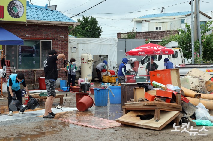 20일 충남 아산시 염치읍 수해 피해마을 주민들과 자원봉사자들이 피해복구 작업을 하고 있다.