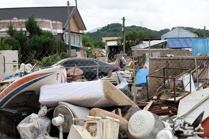 지난 20일 충남 아산시 염치읍 수해 피해마을 주민들과 자원봉사자 및 군부대 장병들이 피해복구 작업을 하는 모습. 윤창원 기자