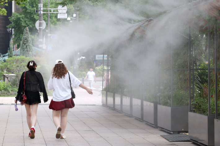 시민들이 쿨링포그 앞을 지나며 더위를 식히고 있다. 류영주 기자