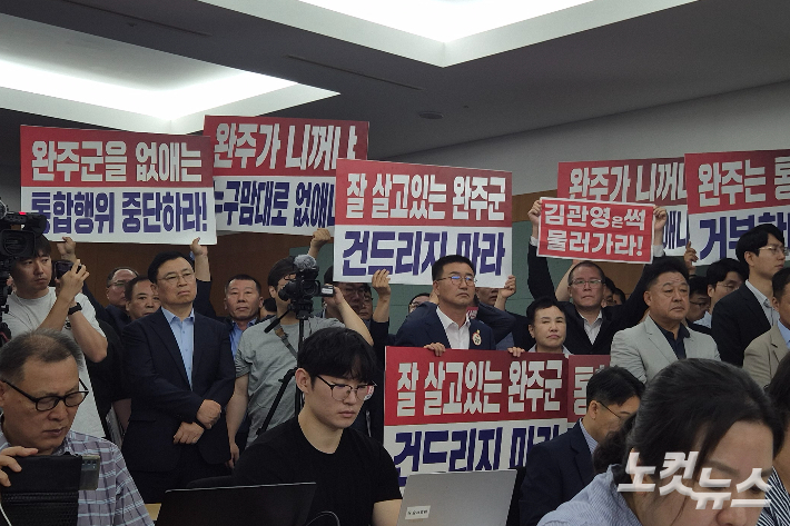 전주-완주 통합 반대단체와 완주군의회 의원들이 전북도청 기자회견을 찾아 팻말을 들고 항의하고 있다. 기자회견 중 종종 고성을 지르기도 했다. 송승민 기자