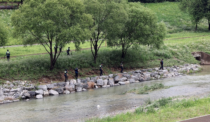 지난 18일 오후 세종시 나성동 제천변에서 경찰이 물에 휩쓸려 실종된 40대 남성을 수색하고 있다. 연합뉴스