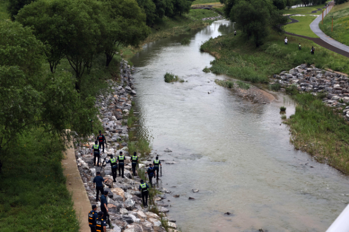 지난 18일 오후 세종시 나성동 제천변에서 경찰이 물에 휩쓸려 실종된 40대 남성을 수색하고 있다. A씨는 전날 오전 1시 50분께 이 근처에서 언덕을 내려가다가 불어난 천변 물에 휩쓸렸다. 연합뉴스