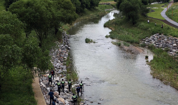 지난 18일 오후 세종시 나성동 제천변에서 경찰이 물에 휩쓸려 실종된 40대 남성을 수색하고 있다. 연합뉴스