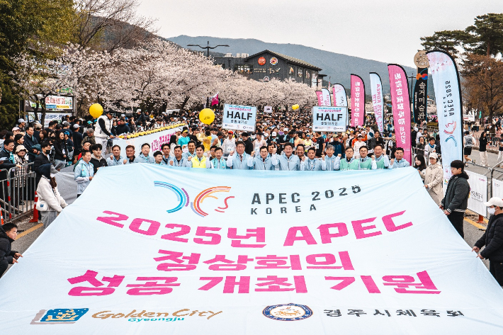 2025 APEC 정상회의 성공 개최를 기원하며 열린 경주 벚꽃마라톤대회 참가자들이 대형 현수막을 펼치고 응원의 메시지를 전하고 있다. 경주시 제공