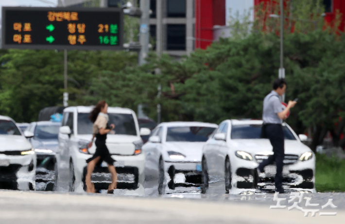 폭염으로 아지랑이가 피어오르는 도로를 시민들이 지나고 있다. 박종민 기자