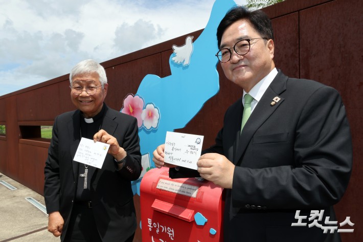 우원식 국회의장과 유흥식 추기경이 23일 경기도 파주 임진각 평화누리공원 통일기원 느린우체통에 메시지를 적은 엽서를 넣고 있다.