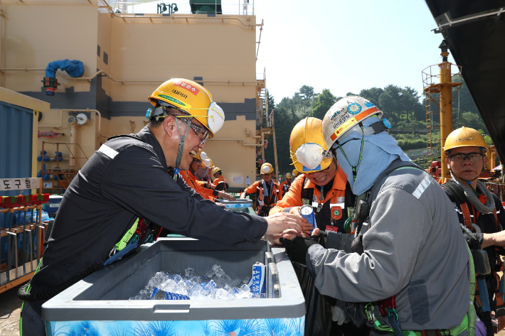 한화오션 김희철 대표이사가 근로자에게 시원한 음료를 건네고 있다. 한화오션 제공 