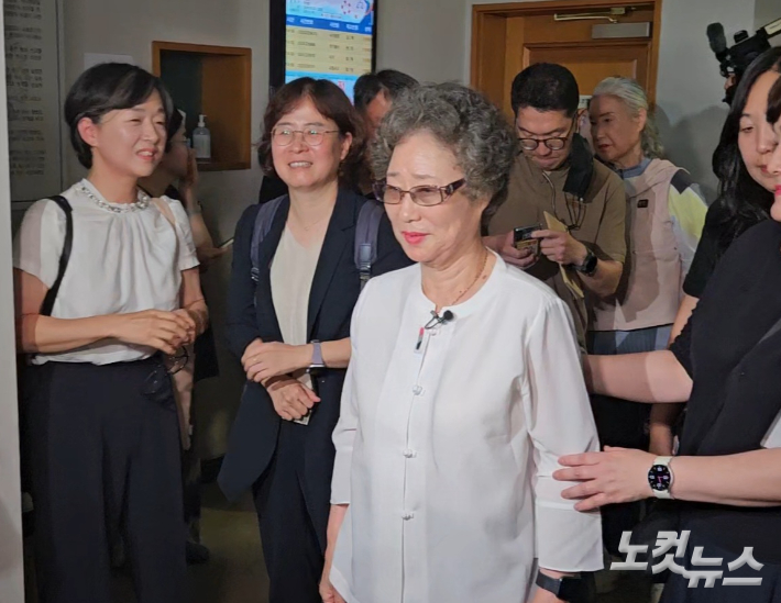 23일 부산지법에서 재심 공판을 마친 최씨가 웃는 얼굴로 법정을 나서고 있다. 김혜민 기자