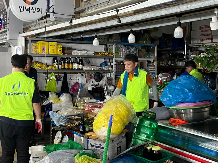 지난 17일 당진전통시장 어시장에서 수해 복구활동에 참여한 충남신용보증재단 조소행 이사장과 임직원들. 충남신보 제공