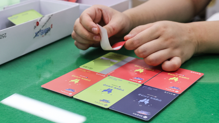 소득 수준에 따라 색상이 달라 논란이 된 광주시 소비 쿠폰 선불카드에 23일 밤에 광주 동구 행정복지센터 공무원이 스티커 부착하고 있다. 광주 동구 제공